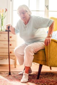 Elderly woman seated with cane